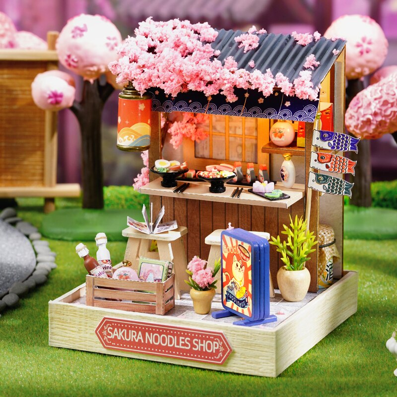 a miniature model of a store with pink flowers